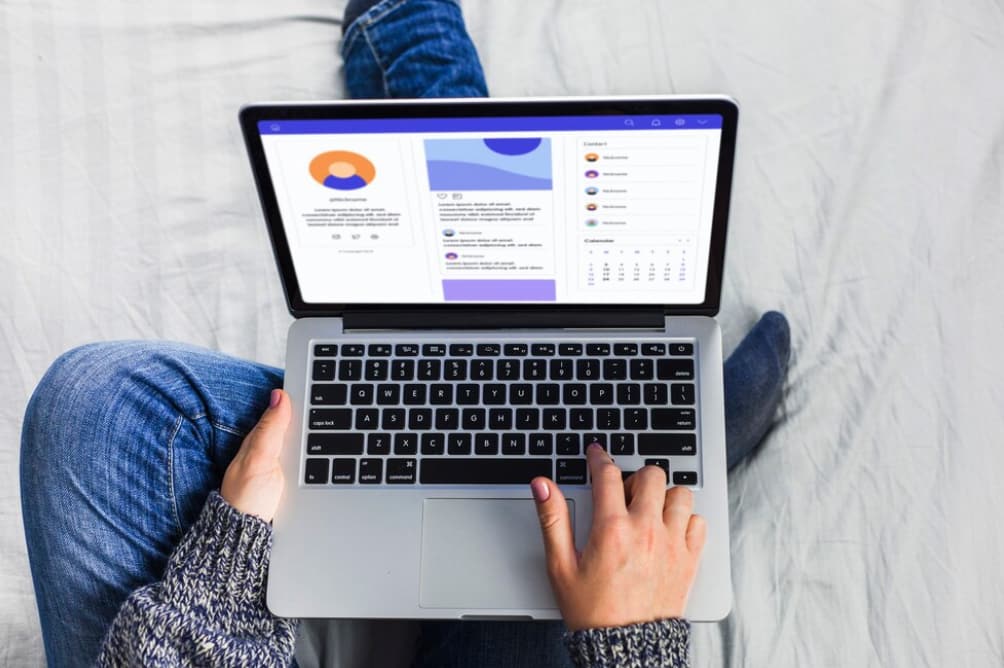 Overhead view of a person using a laptop with data charts on the screen